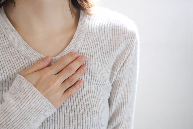 胸を抑える女性