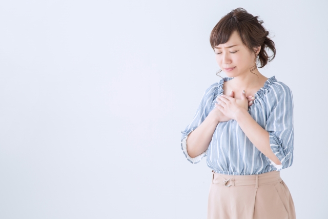 胸を抑える女性