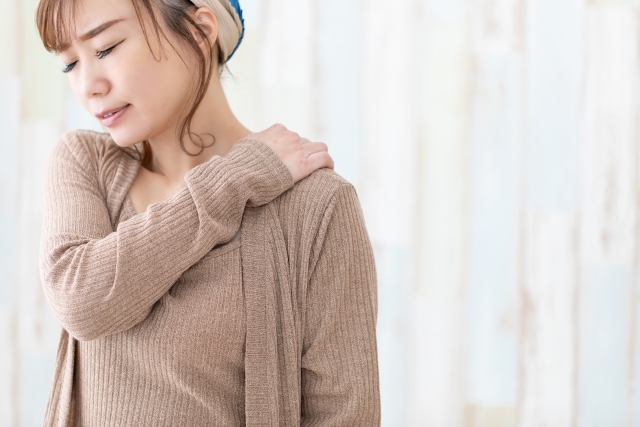 背中の痛みを気にする女性