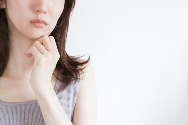 顎に手を当てて考える女性